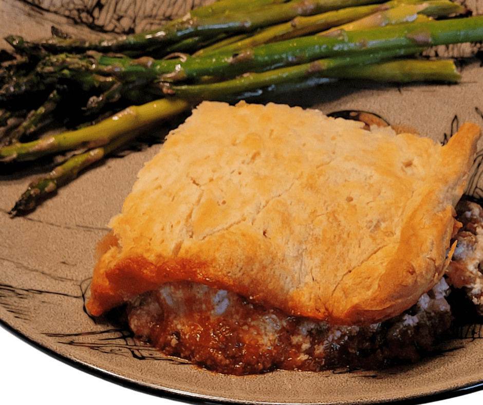 Ranch Hand Casserole on a plate with roasted asparagus.